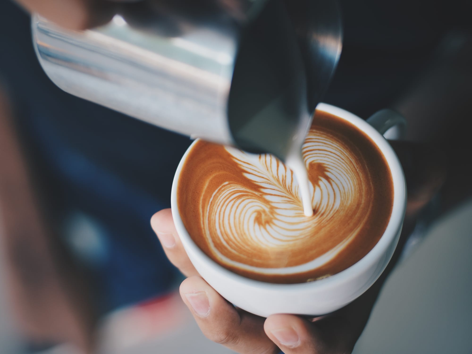 person-serving-cup-coffee-with-metal-jug.jpg